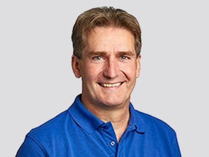 Mitarbeiter von Schoop Gartenbau in blauem Poloshirt mit Logo, Experte für Gartenbau Aargau und Gartenpflege